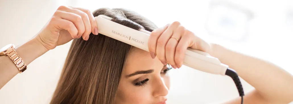 Frau verwendet Remington Glätteisen