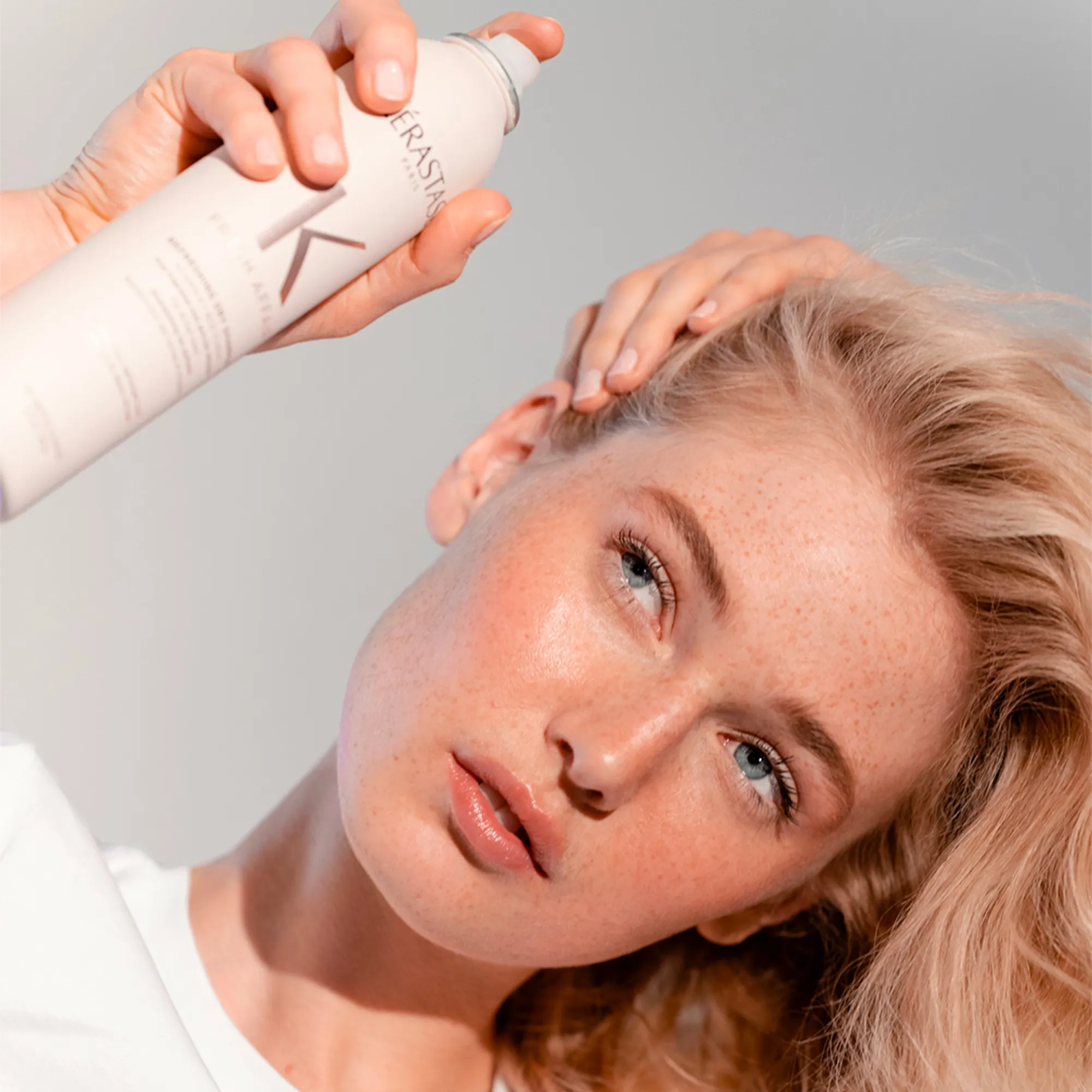 Frau mit Kérastase Fresh Affair Trockenshampoo